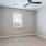 a room with a ceiling fan and a carpet