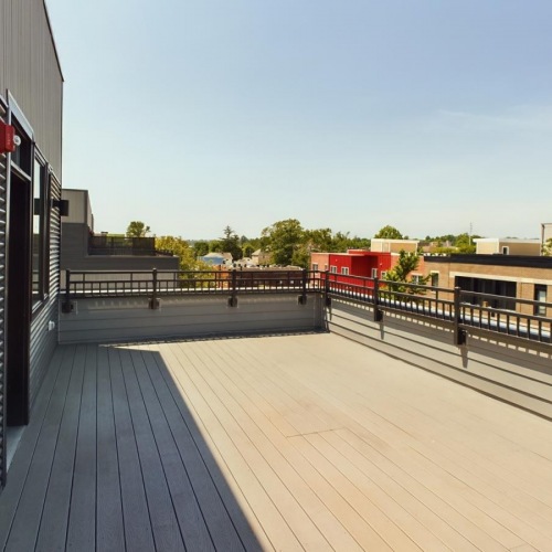 a wooden porch with buildings on either side of it